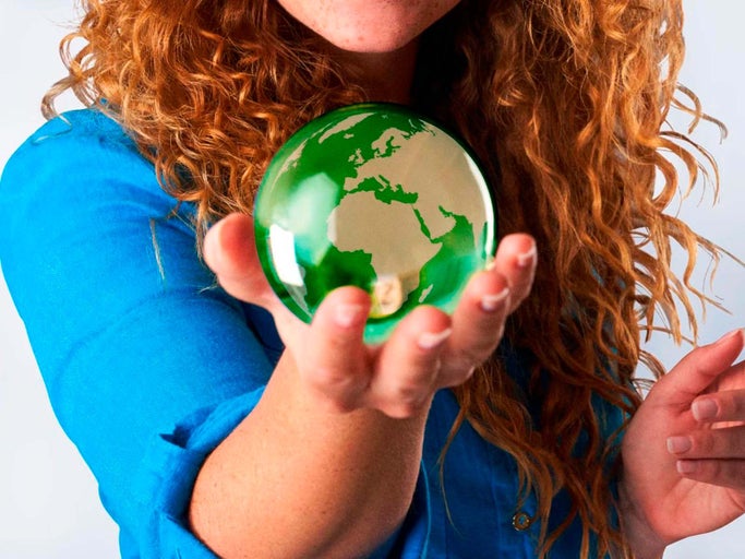 Žena drží v ruke zelenú zemeguľu