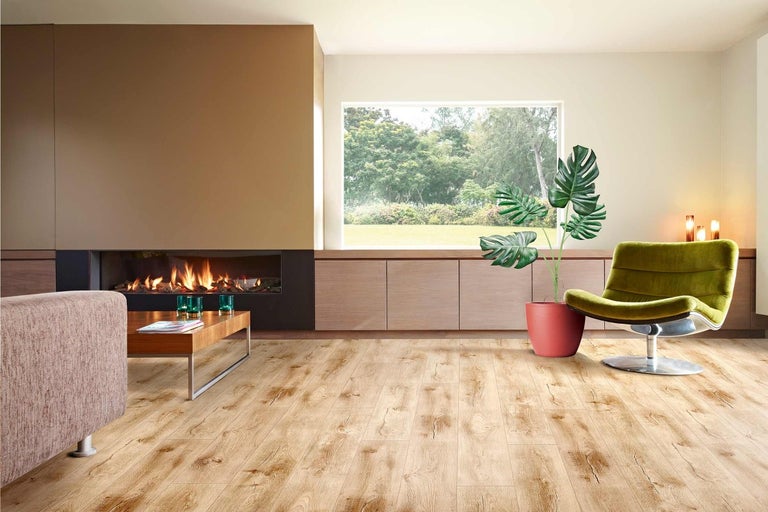 Svetlá obývacia izba s drevenou podlahou, krbom a izbovou rastlinou