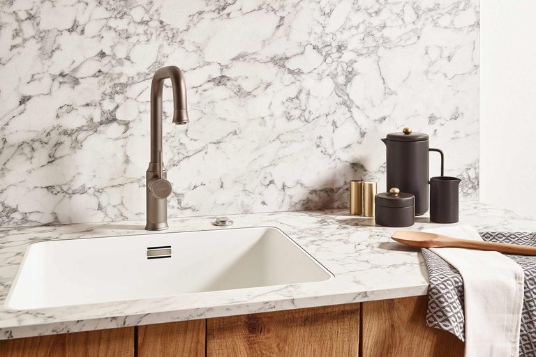 Kuchynská scéna s drezom, batériou a kuchynským náčiním na mramorovej doske