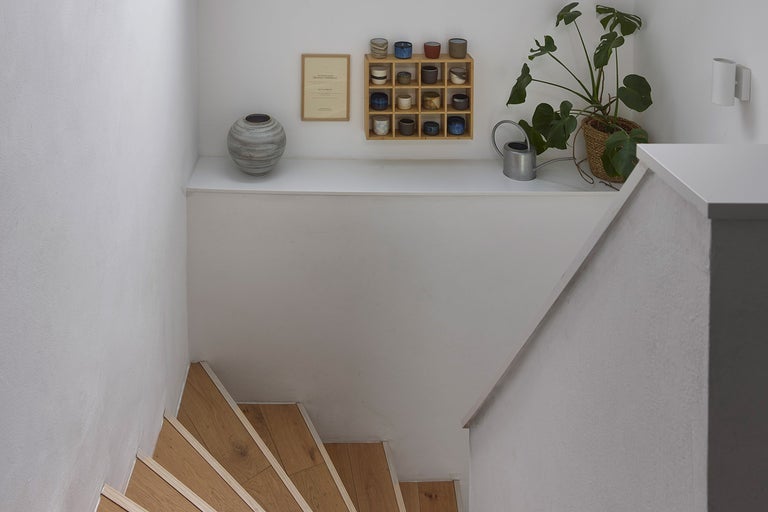 Svetlá miestnosť so schodiskom, dekoráciami a izbovou rastlinou