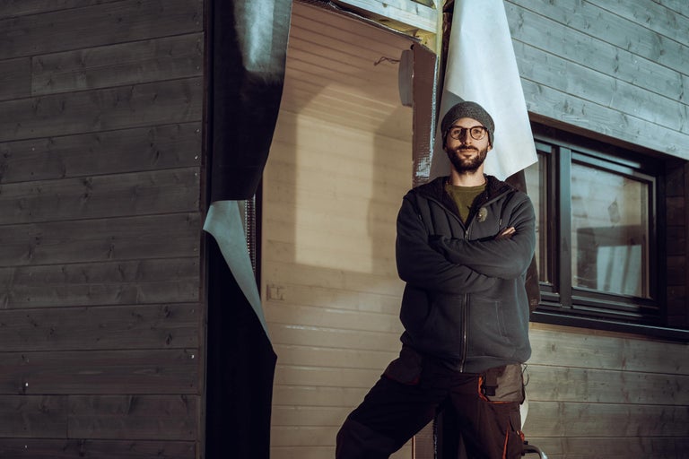 Exteriér domu s dreveným obkladom a osobou