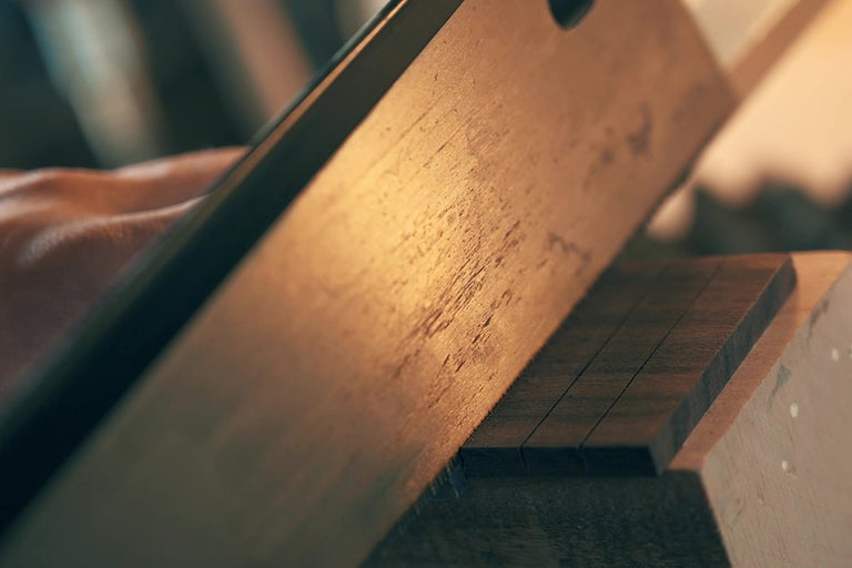 Remeselník pília drevenú lištu ručnou pílou