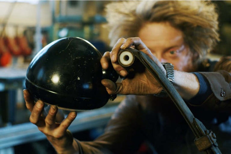 Muž drží v ruke lampu