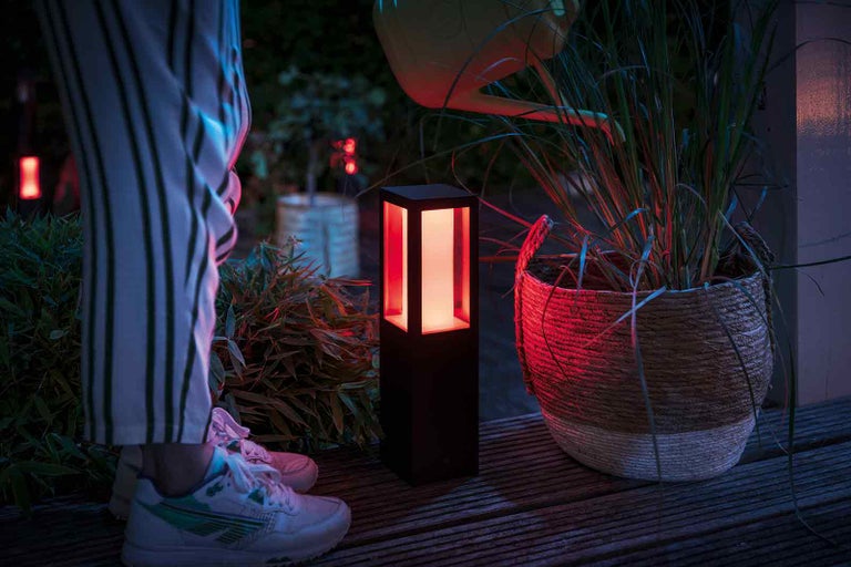 Dekoratívna záhradná lampa vedľa kvetináča vonku