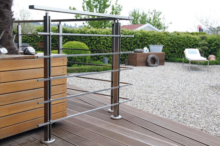 Vonkajšia fotografia nerezového zábradlia na drevenej terase so štrkom v záhrade