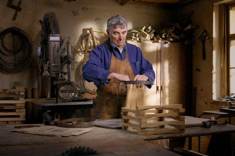 Remeselník v dielni vyrába drevený sud.