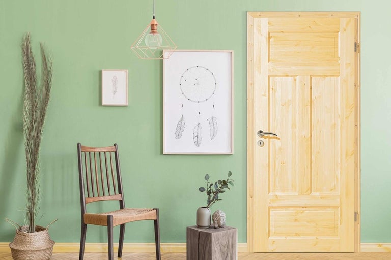 Obývacia izba s drevenými dverami, stoličkou, dekoráciou a obrazmi pre štýlové prostredie