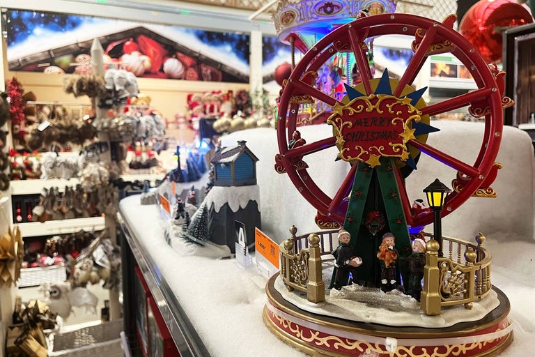 Vianočná dekorácia s osvetleným ruským kolesom a miniatúrnymi figúrkami.