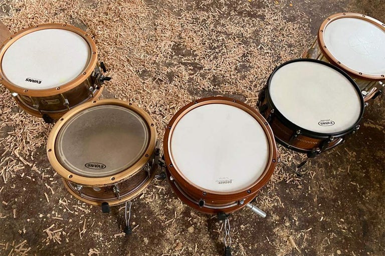 Niekoľko bubnov s dreveným rámom a blanami značiek Evans a Premier