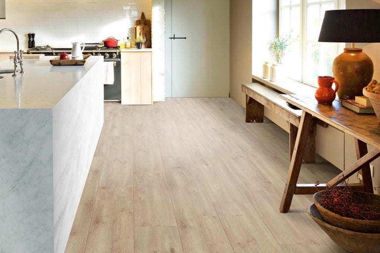 Svetlá laminátová podlaha v kuchyni a obývacej izbe.