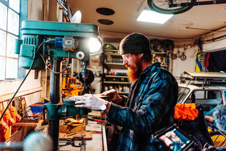 Muž pracuje so stĺpovou vŕtačkou v dielni.