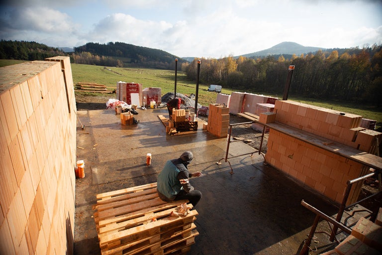 Stavenisko s pórobetónovými tvárnicami a pracovníkmi vonku