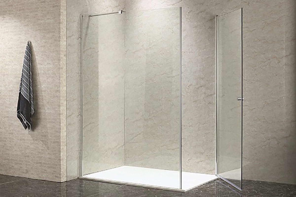 Sprchovací kút so zástenou s uterákom a sprchovacou vaničkou v kúpeľni.