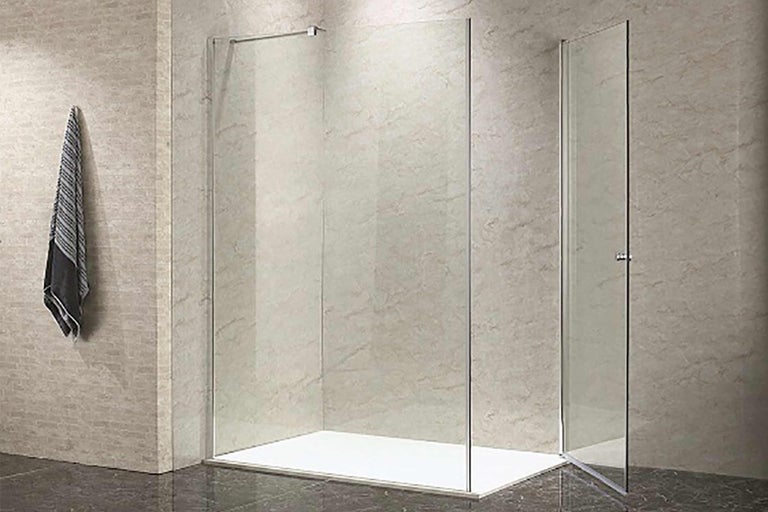 Sprchovací kút so zástenou s uterákom a sprchovacou vaničkou v kúpeľni.