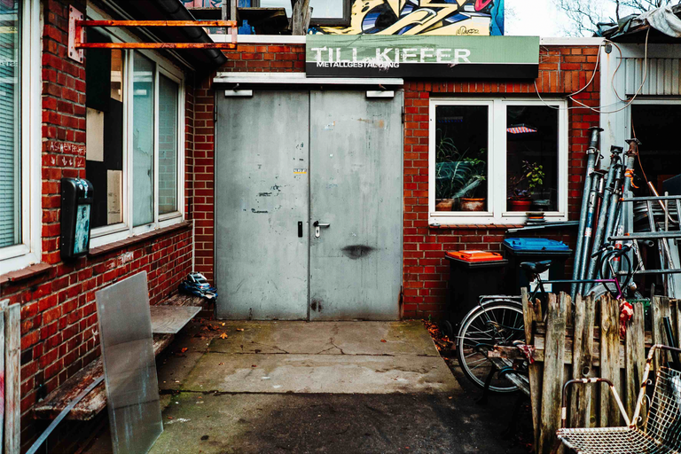 Vonkajší pohľad na kovovýrobný závod s tehlovou stenou, dvojkrídlovými dverami a oknami.