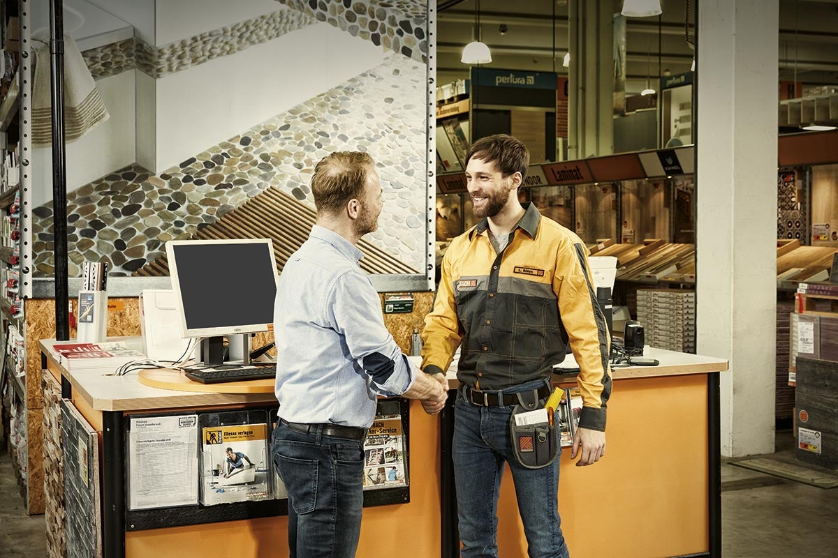 Dvaja muži si potriasajú rukami v hobby markete Hornbach.