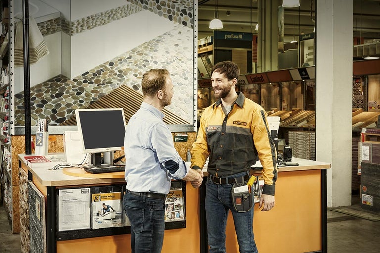 Dvaja muži si potriasajú rukami v hobby markete Hornbach.