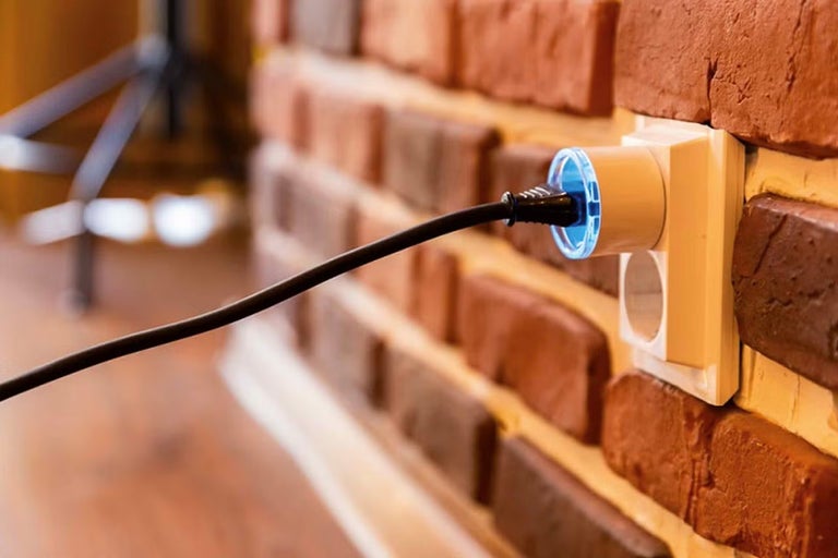 Zásuvka so zástrčkou v tehlovej stene