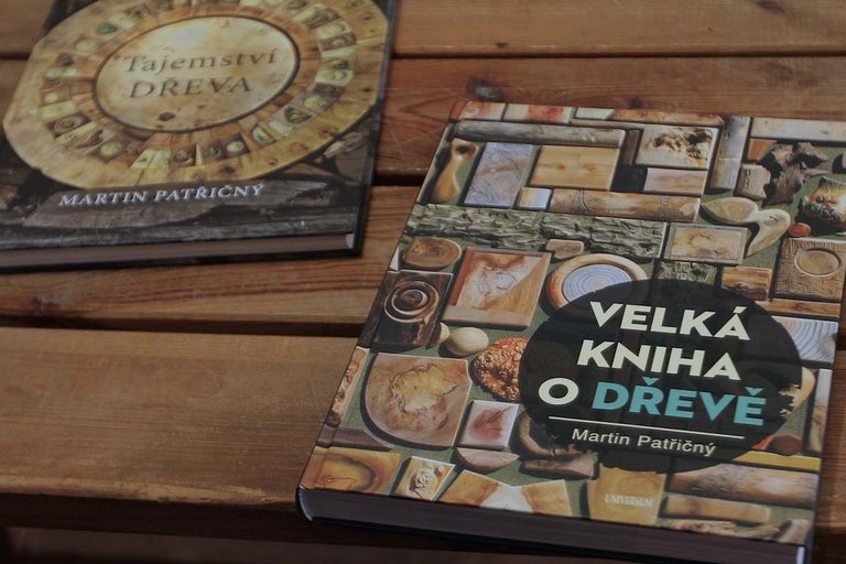 Dve knihy na tému dreva ležia na drevenom stole.