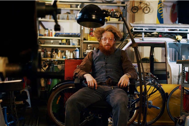 Dielňa s osobou, bicyklami a náradím v pozadí