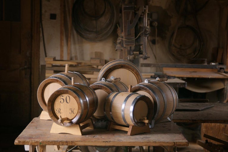 Niekoľko malých drevených sudov na stole v dielni.