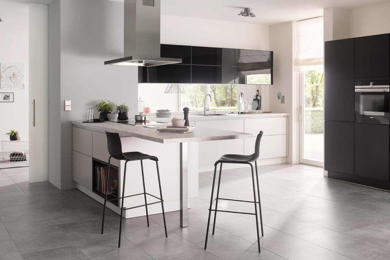 Moderná kuchyňa s kuchynským ostrovčekom, barovými stoličkami, digestorom a vstavanými skriňami vo svetlom a priestrannom dizajne.