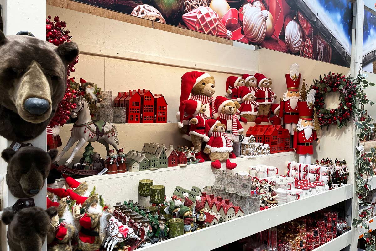 Vianočné dekorácie v obchode Hornbach, vrátane plyšových medveďov, luskáčikov a domov