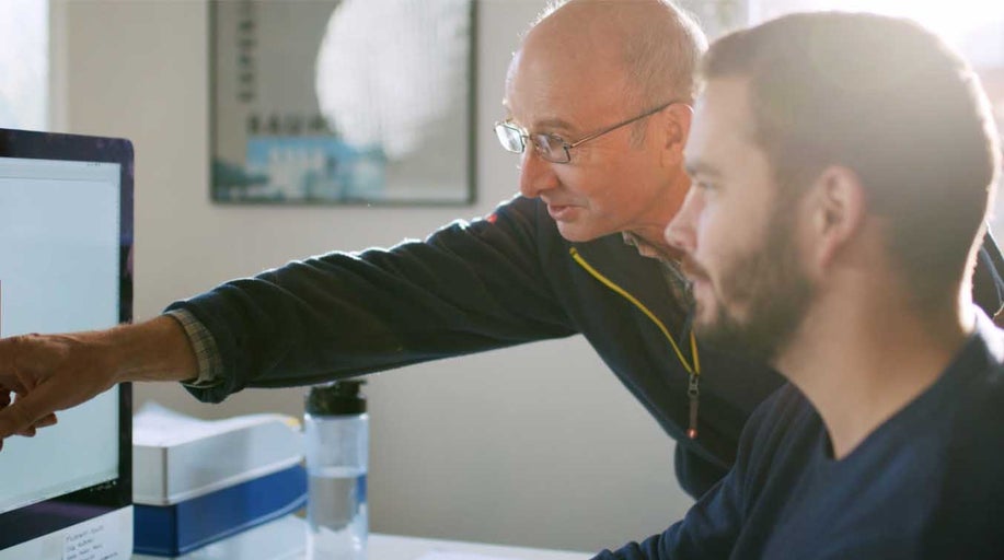 Dvaja ľudia pracujú spoločne na počítači