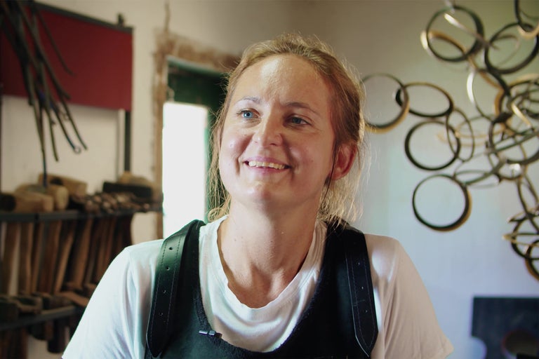 Portrét usmievavej ženy v dielni s náradím