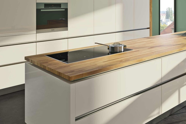 Kuchynský ostrovček s drevenou pracovnou doskou, indukčnou varnou doskou a hrncom