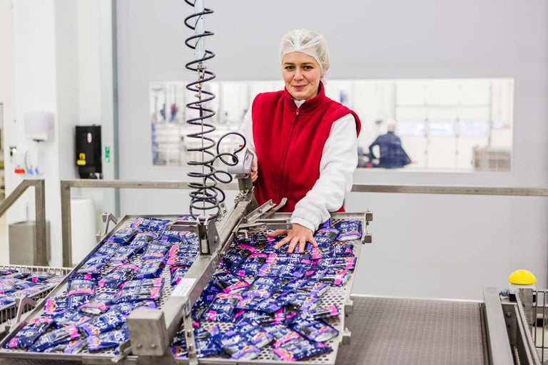 Žena balí produkty na montážnej linke v továrni
