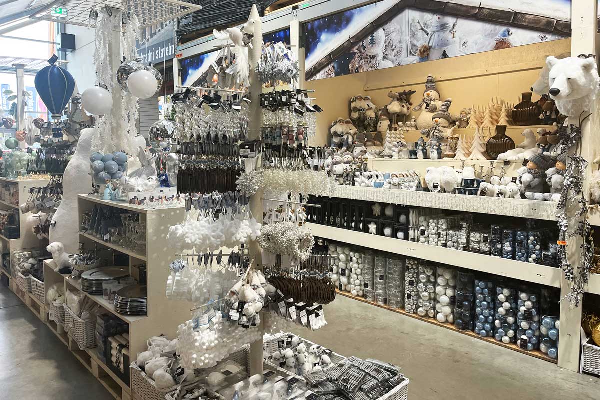 Dekoratívna vianočná scéna s výberom sezónnych ozdôb a figúrok v obchode.