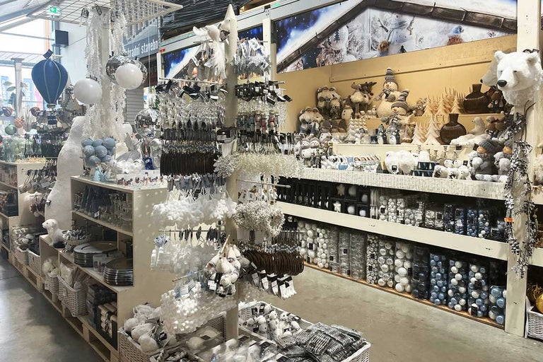 Dekoratívna vianočná scéna s výberom sezónnych ozdôb a figúrok v obchode.