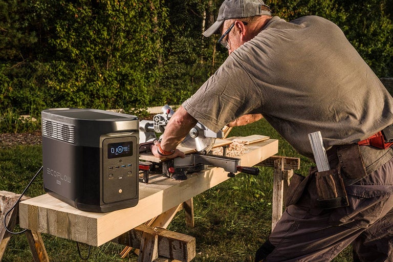 Remeselník reže vonku drevo s prenosnou elektrárňou EcoFlow.