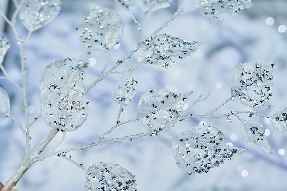 Dekoratívna vetva s trblietavými listami na sviatočné dekorácie