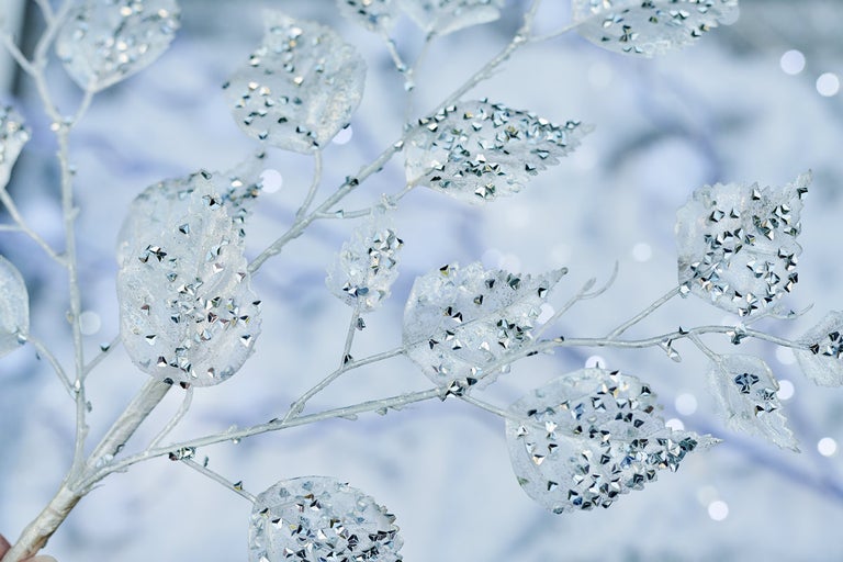 Dekoratívna vetva s trblietavými listami na sviatočné dekorácie