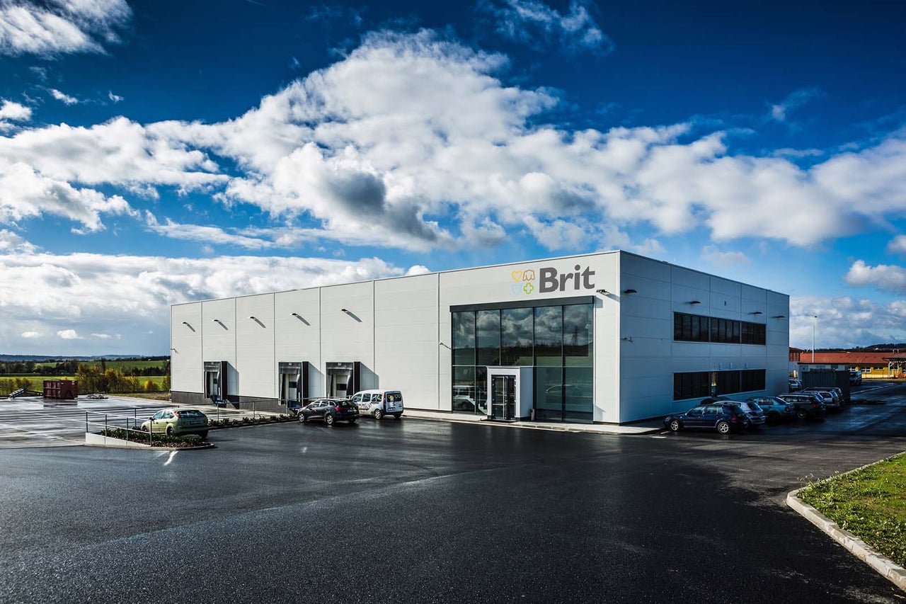 Firemná budova Brit s parkoviskom.