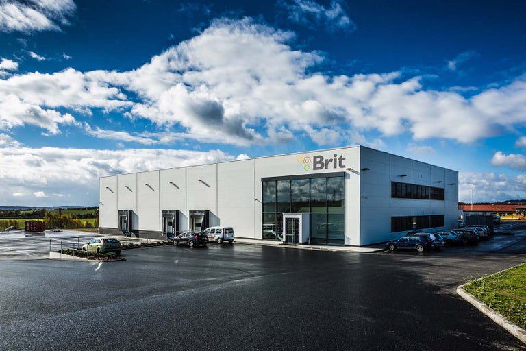 Firemná budova Brit s parkoviskom.