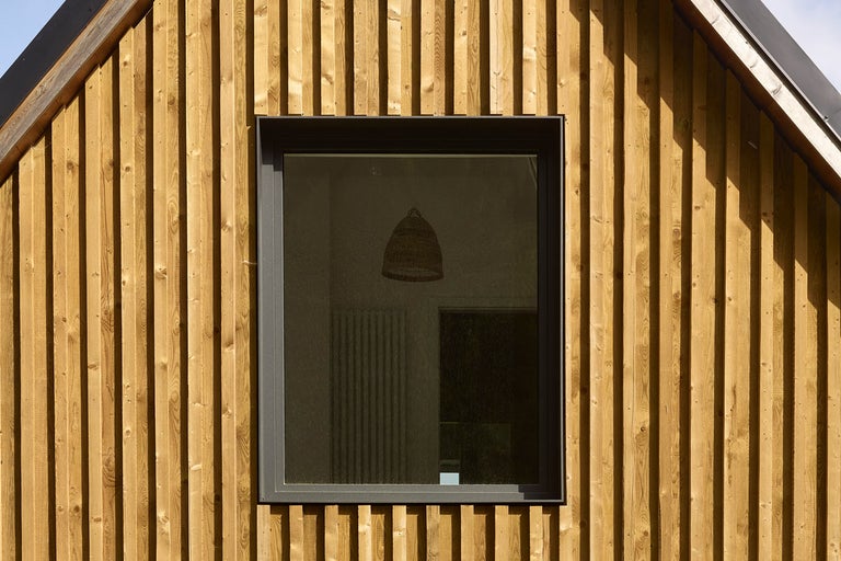 Fasáda s dreveným obkladom a oknom