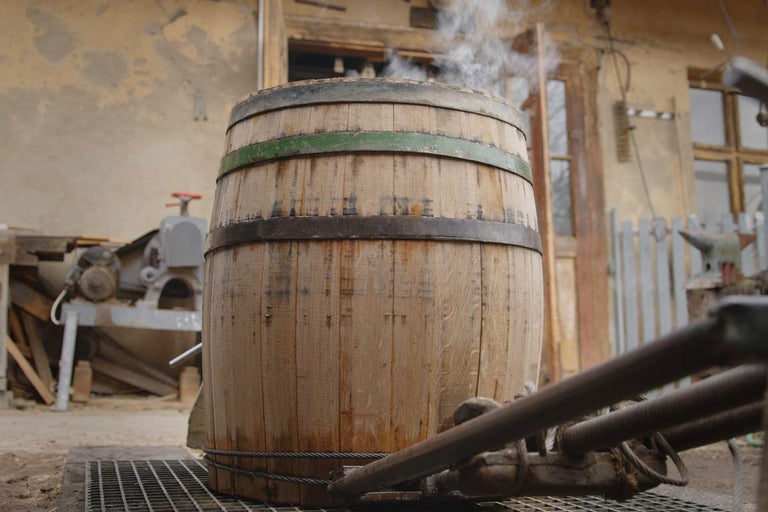 Drevený sud s kovovými pásmi a unikajúcou parou