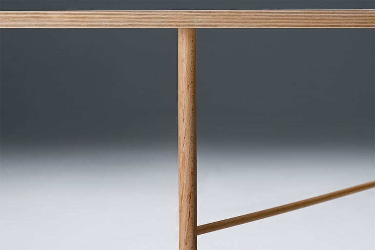 Detailný pohľad na drevený stôl s okrúhlymi nohami a drevenou doskou