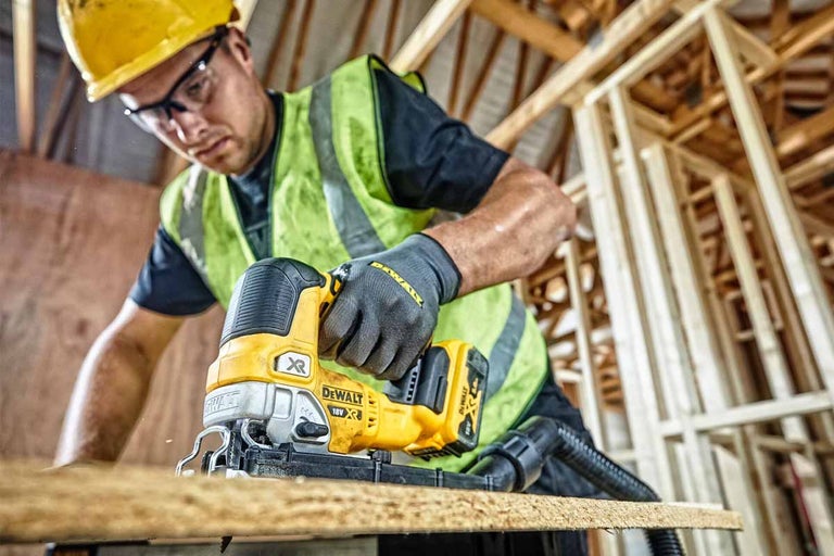 Remeselník používa priamočiaru pílu DeWalt na rezanie dreva.
