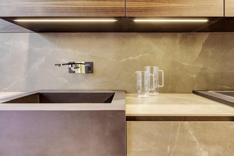 Detail modernej kuchyne s umývadlom, batériou a dvoma sklenenými džbánmi