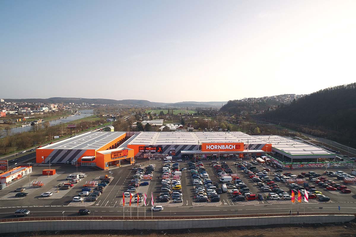 Letecký pohľad na hobbymarket Hornbach s parkoviskom a okolitou krajinou.