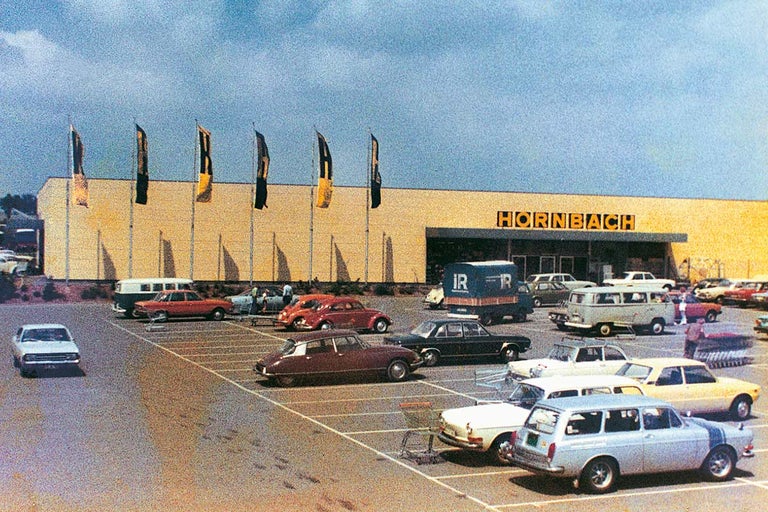 Historická fotografia obchodu Hornbach so stavebninami s parkoviskom a rôznymi autami.