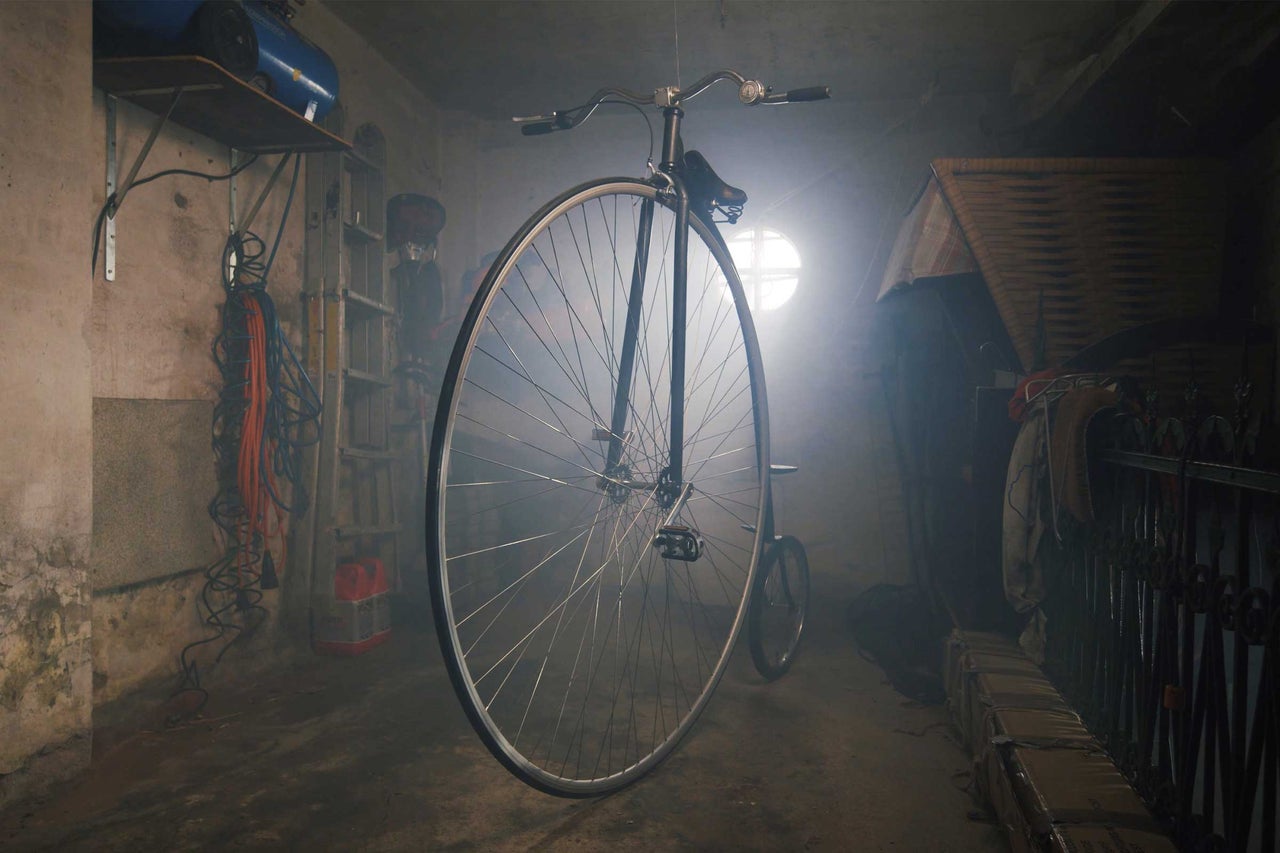 Vysoký bicykel v miestnosti s regálmi a náradím