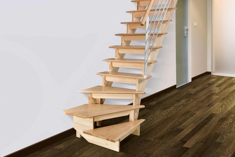 Pohľad do miestnosti s dreveným schodiskom s kovovým zábradlím.