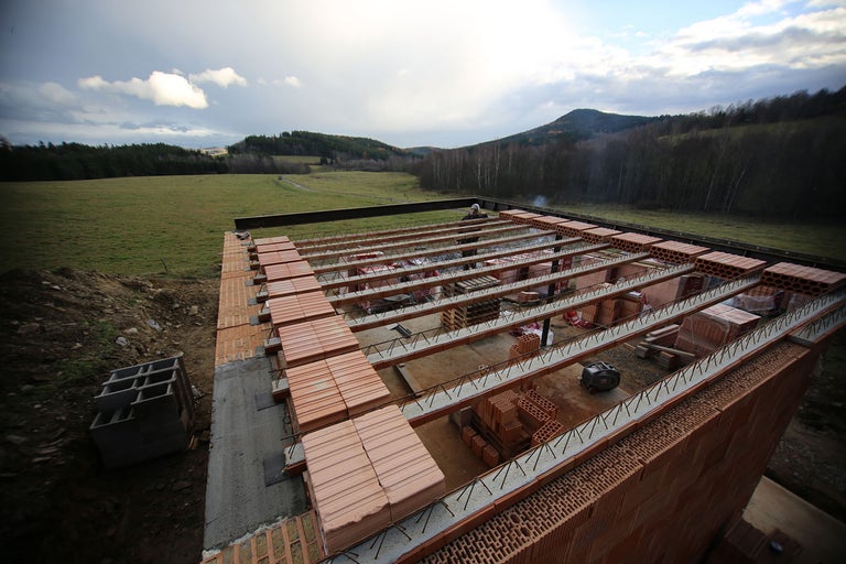 Stavenisko s tehlami a oceľovými nosníkmi na stavbu domu