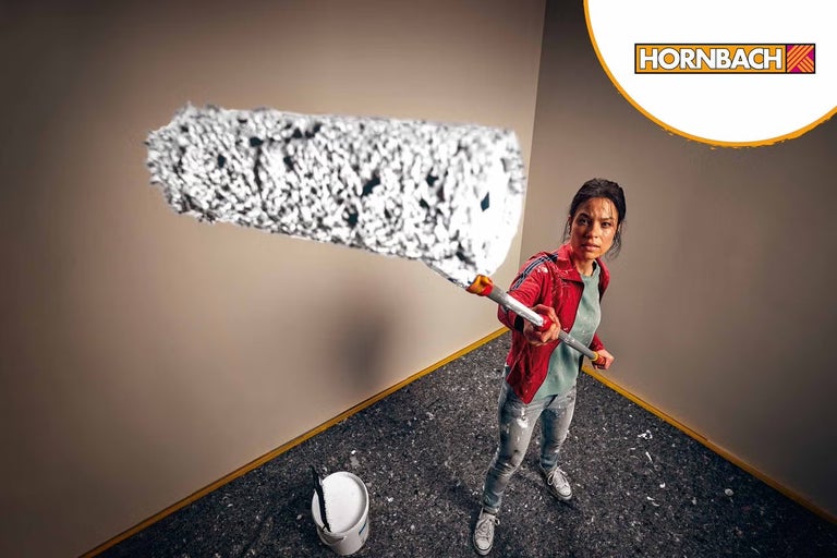 Žena drží veľký valček na maľovanie steny, s logom Hornbach.
