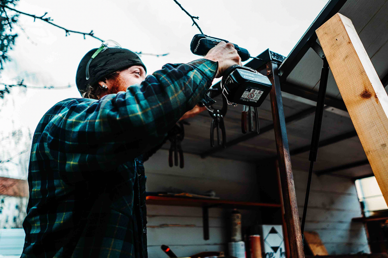 Osoba pracuje s akumulátorovým skrutkovačom na drevenej konštrukcii.